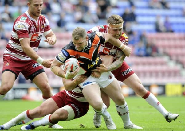 Castleford's Danny Tickle is held back by Wigan's Sam Powell and Matty Smith.  Picture: Bruce Rollinson