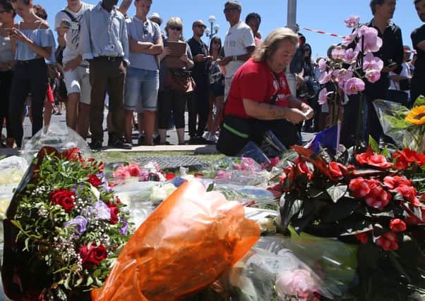 Floral tributes are laid out near the site of the truck attack in the French resort city of Nice. (AP Photo/Luca Bruno)