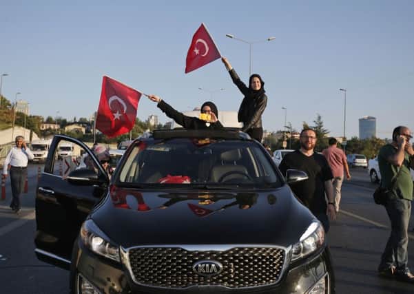 Turkish people wave the national flags on a car in Istanbul, Turkey.