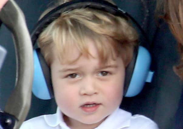 JULY 2016: Prince George wears ear defenders as he sits in a helicopter, during a visit to the Royal International Air Tattoo at RAF Fairford - the world's largest military airshow, with his parents the Duke and Duchess of Cambridge.