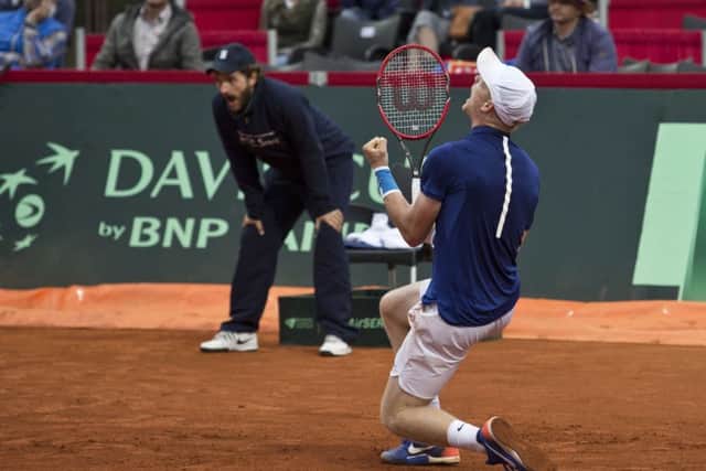Britain's Kyle Edmund, front, drops to his knees in celebration.