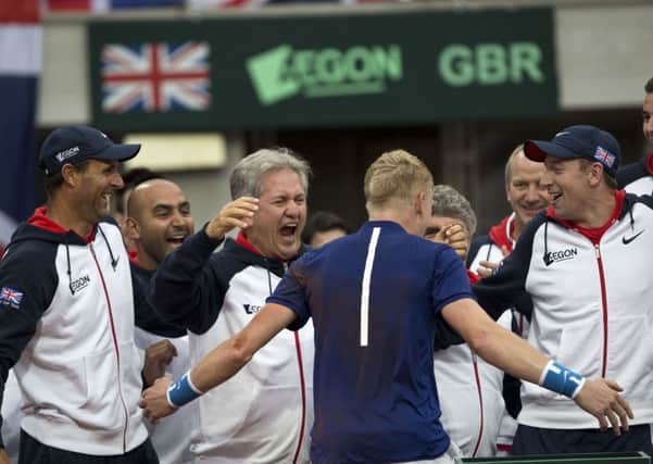 Britain's Kyle Edmund, center, hugs his team members after having won his Davis Cup quarterfinal tennis match.