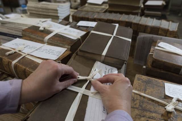 Sara Land, Archive Assistant, tying up some of the smaller books.
Picture James Hardisty.
