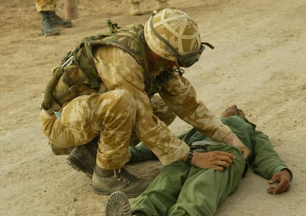 A Royal Marine searches a prisoner during the 2003 Iraq War. Photo credit: PA/PA Wire