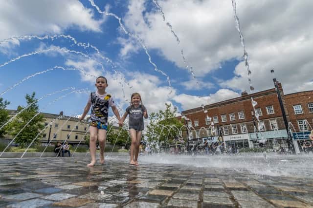 Two youngsters cool down in the water fountain in the centre of Wakefield as tempertures sore across the UK. Picture: James Hardisty
