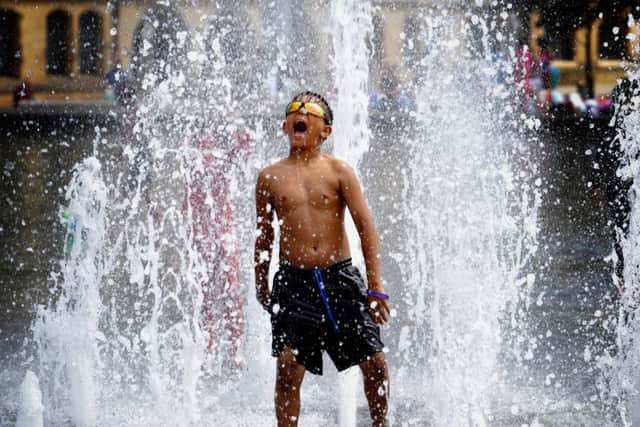 Children play in the water fountains at City Park, Bradford, as the temperatures rise. Picture by Simon Hulme