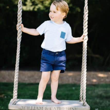 Picture of Prince George, who celebrates his third birthday today, standing on a swing. The picture was taken at the family's Norfolk home in mid-July by Matt Porteous.