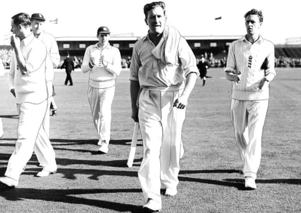 Jim Laker leads the England team off the field at Old Trafford in 1956 after taking 19 Australian wickets.