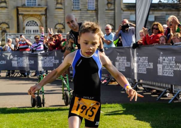 Bailey Matthews, from Doncaster, crosses the finish line  to complete his first ever triathlon at Castle Howard.