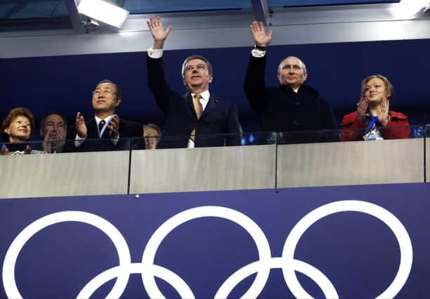Russian President Vladimir Putin, second from right, and International Olympic Committee President Thomas Bach, centre, wave as they stand alongside United Nations Secretary-General Ban Ki-moon, third from left, during the opening ceremony of the 2014 Winter Olympics in Sochi, Russia.  (AP Photo/Mark Humphrey)