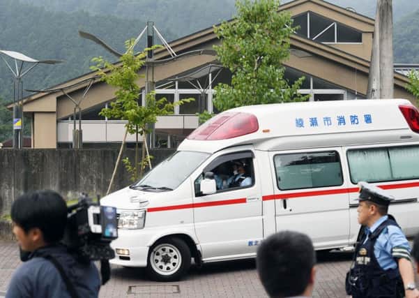 An ambulance moves past in front of the facility. (Kyodo News via AP)