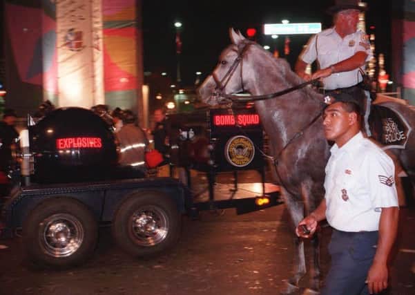 Law enforcement officials are pictured next to bomb squad equipment outside Centennial Olympic Park, Saturday, July 27, 1996, in Atlanta. (AP Photo/Beth Flynn)