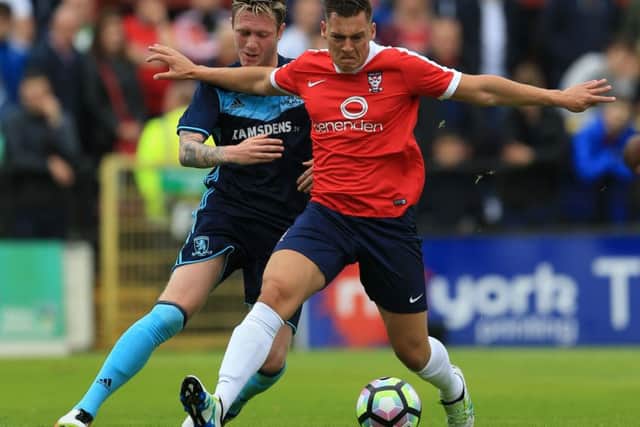 York City's Scott Fenwick (front) and Middlesbrough's Jordan McGhee battle for the ball during a pre-Season friendly at Bootham Crescent. Picture: Nigel French/PA.