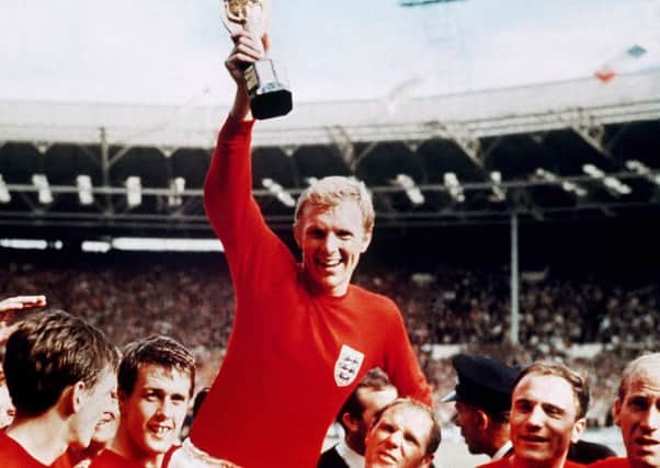 Captain Bobby Moore, carried shoulder high by his team mates, holds aloft the Jules Rimet trophy, after England's victory over West Germany in the 1966 World Cup Final. (AP Photo).