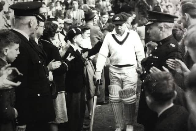 LEGEND: Sir Donald Bradman is patted lovingly by one of the many boys to whom he was a hero as he walks out at Headingley for the last time in 1948. He did not disappoint his admirers, making 173 not out in a memorable Australian victory.