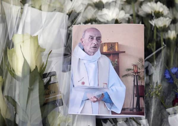 A picture of late Father Jacques Hamel is placed on flowers at the makeshift memorial in France to the priest who was murdered while conducting Mass. Daesh, the so-called Islamic State, has claimed responsibility.