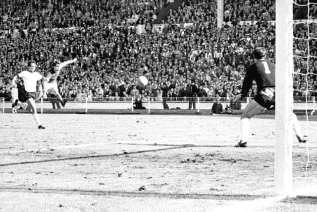 England's Geoff Hurst cracks a shot past German goalkeeper Hans Tilkowski to score the final goal of the World Cup Final against West Germany at Wembley.