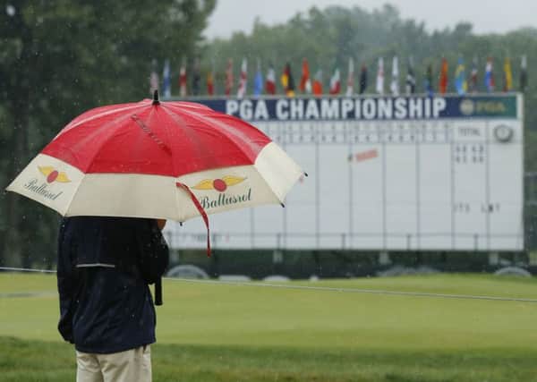 Washout: A man stands by the 18th hole after third round play was suspend for the day at the PGA Championship.
Picture: AP Photo/Tony Gutierrez