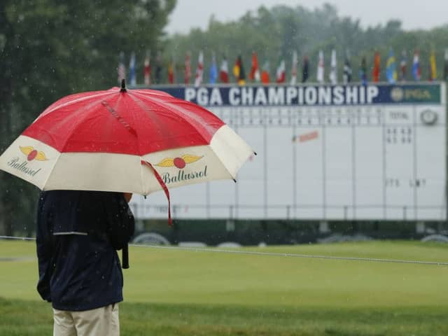 Washout: A man stands by the 18th hole after third round play was suspend for the day at the PGA Championship.
Picture: AP Photo/Tony Gutierrez