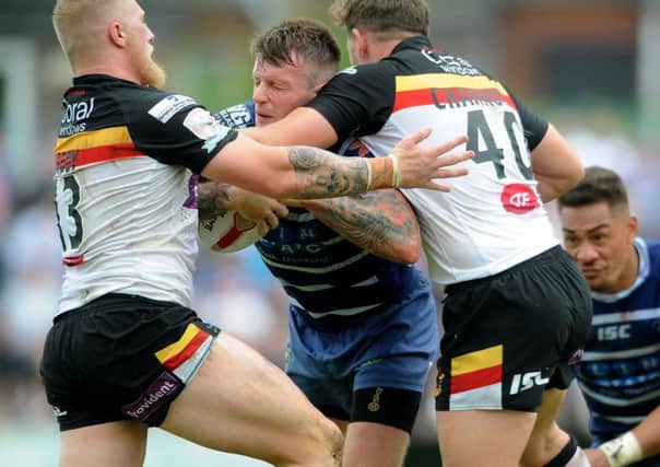 Featherstone Rovers' Anthony Thackeray, is tackled by Bradford Bulls Danny Addy, and Lewis Charnock.