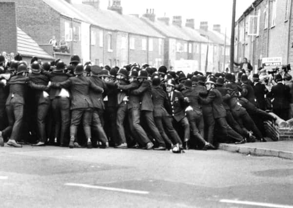 August 21st 1984.

A line of police contains pickets in a side street opposite Allerton Bywater Colliery.