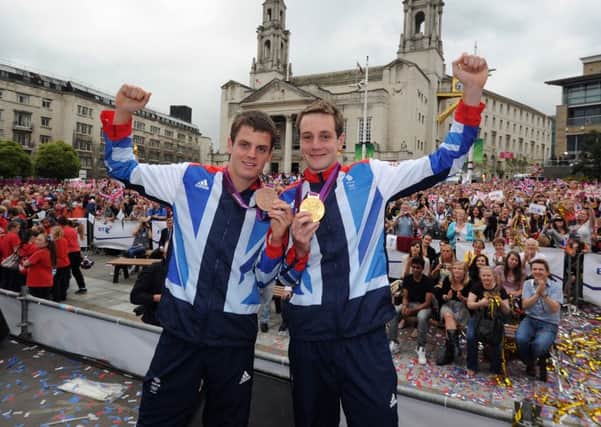 Olympic gold winning triathlete Alistair Brownlee and his Bronze winning Jonny Brownlee, celebrate at Millennium Square, Leeds in 2012.