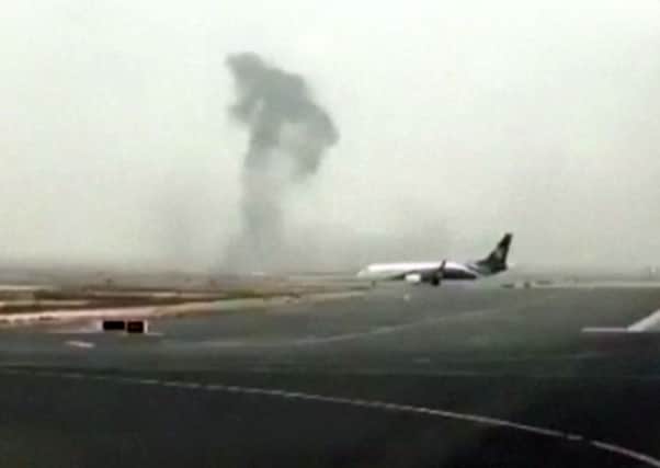 This image made from video shows smoke rising after an Emirates flight crash landed at Dubai