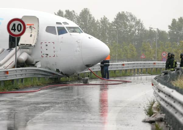 Firefighters work on DHL cargo plane that skidded off a runway at Orio al Serio airport overnight,  busting through a perimeter fence and onto a provincial highway, near Bergamo in Northern Italy,