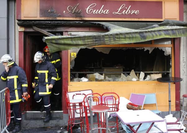 Firefighters leave the bar where a fire broke in Rouen, western France. A fire swept through a birthday party on Friday night at a bar in the Normandy city of Rouen, killing at least 13 people and injuring six others, French authorities said. AP Photo/Kamil Zihnioglu