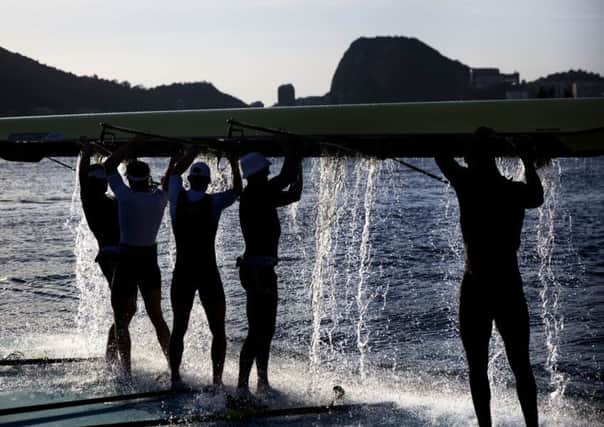 Rowers from Great Britain dump water out of their boat after a practice session at the rowing venue in Lagoa at the 2016 Summer Olympics in Rio de Janeiro, Brazil, Sunday (AP Photo/David Goldman)