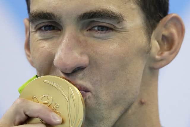 United States' Michael Phelps kisses his gold medal