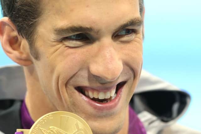 Phelps pictured here with one of his gold medals at the London 2012 Olympics. (PA).