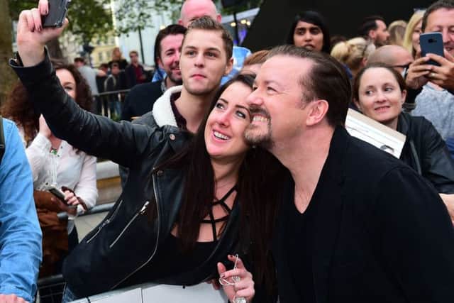 Ricky Gervais takes selfies with fans attending the world premiere of David Brent: Life On The Road at Leicester Square, London.