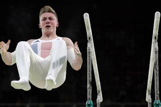 Wilson flies through the air at the end of his horizontal bars routine (PA)