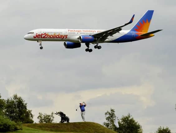 A golfer takes a shot as the Jet 2 flight from Alicante lands at Leeds Bradford Airport