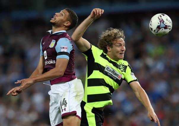 Aston Villa's Rudy Gestede and Huddersfield Town's Michael Hefele battle for the ball
