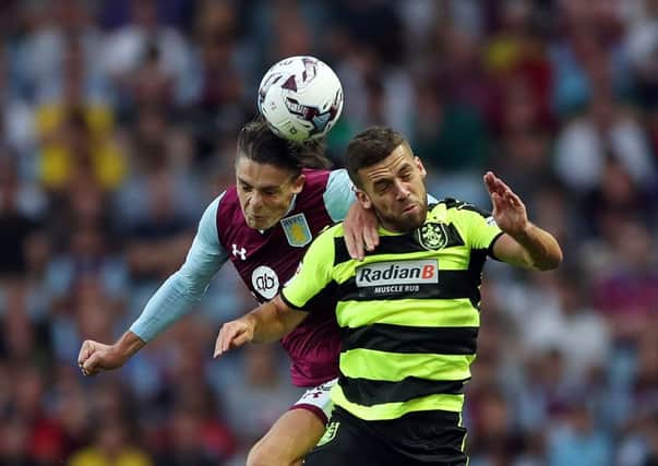 Aston Villa's Jack Grealish (left) and Huddersfield Town's Tommy Smith battle for the ball