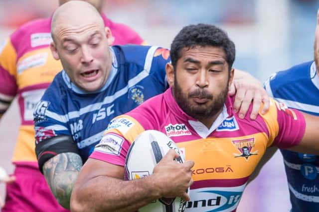Huddersfield's Sebastine Ikahihifo is tackled by Featherstone's John Davies.