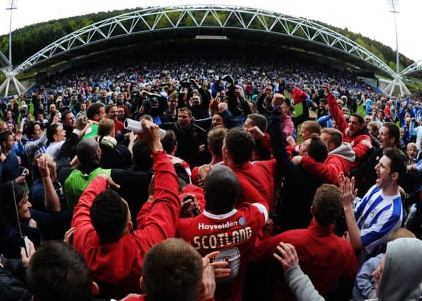 We are staying up: 
Huddersfield Town and Barnsley fans and players celebrate after surviving the drop with a 2-2 final-day draw