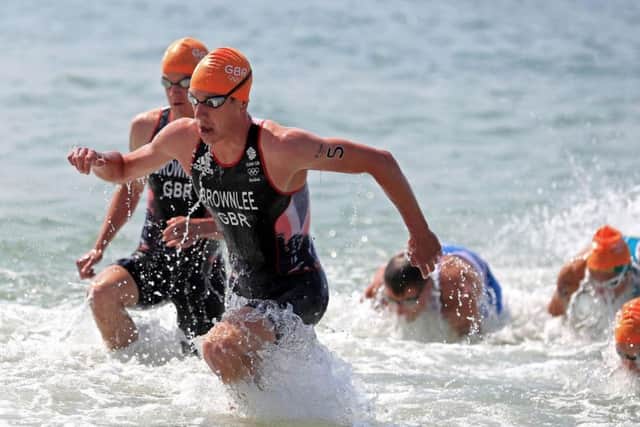 Alistair Brownlee races out of the water (PA)