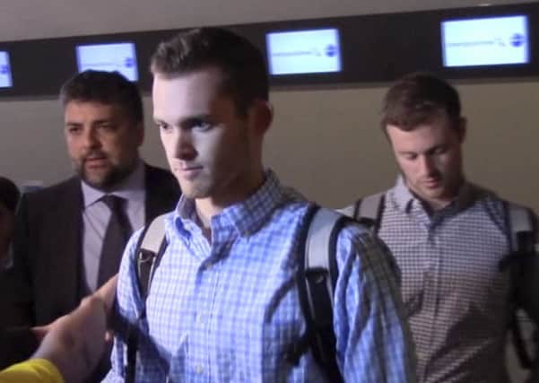 In this image made from video, American Olympic swimmers Gunnar Bentz and Jack Conger walk in the departure area after checking into their flight at the airport in Rio de Janeiro, Brazil. (AP Photo)