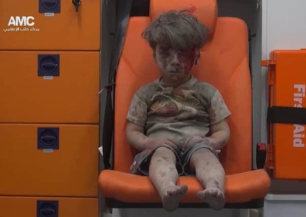 In this frame grab taken from video provided by the Syrian anti-government activist group Aleppo Media Center (AMC), a child sits in an ambulance after being pulled out or a building hit by an airstirke, in Aleppo, Syria, Wednesday. Picture: Aleppo Media Center via AP.