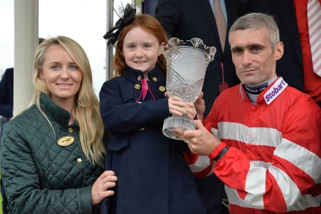 Jockey Paul Mulrennan holds the trophy with his daughter Scarlett and wife Adele after riding Mecca's Angel to victory in the Coolmore Nunthorpe Stakes at the Ebor Festival at York. Picture: Anna Gowthorpe/PA
