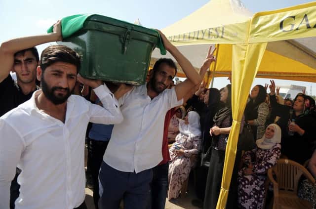 People carry a victim's coffin as they attend funeral services for dozens of people killed in last night's bomb attack targeting an outdoor wedding party in Gaziantep, southeastern Turkey.