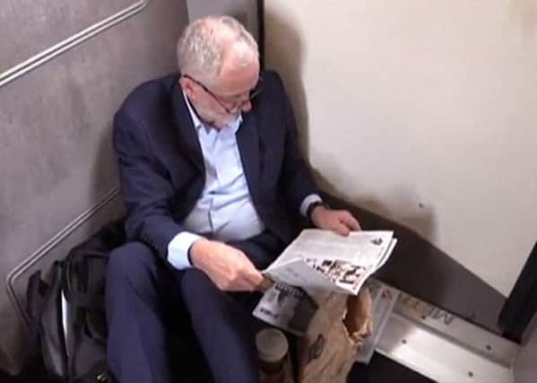 Jeremy Corbyn sitting on the floor of a train, as seen in a Guardian video