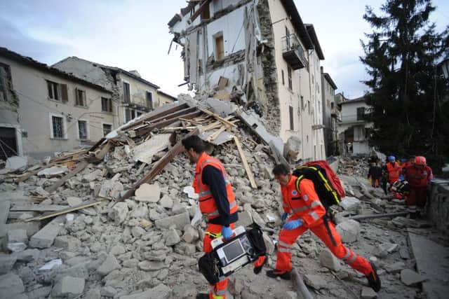 Rescuers search a crumbled building in Arcuata del Tronto, central Italy, where a 6.1 earthquake struck this morning.