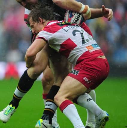 Hull FC's Gareth Ellis is tackled by Wigan's Ben Flower (left) and Logan Tomkins during the Challenge Cup Final defeat at Wembley back in 2013. Picture: Anna Gowthorpe/PA.