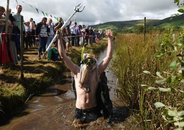 Chris Lyness, dressed as King Neptune, takes part in the 31st World Bog Snorkelling Championships at Waen Rhydd peat bog. Picture: Joe Giddens/PA Wire