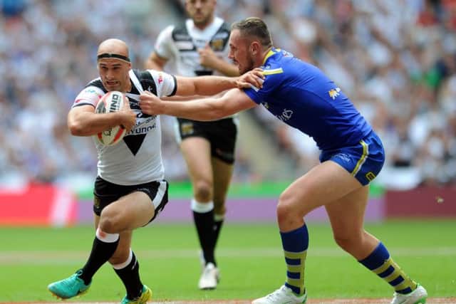 Hull's Danny Houghton is tackled by Warrington's Ben Currie. (Picture: Jonathan Gawthorpe)