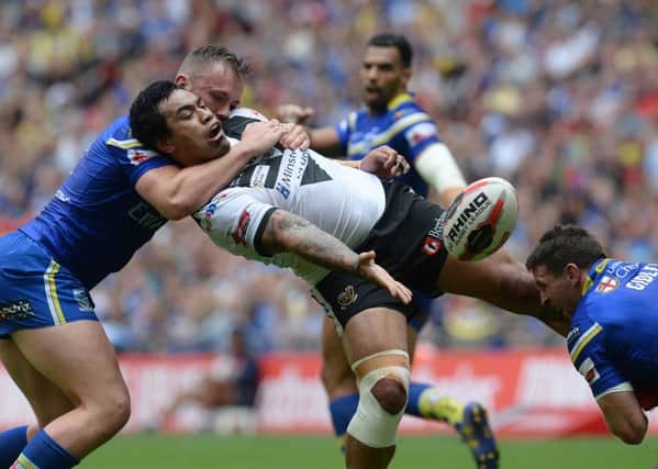 Hull FC's Mahe Fonua passes the ball under pressure from Warrington Wolves' Ben Currie and Kurt Gidley (right)